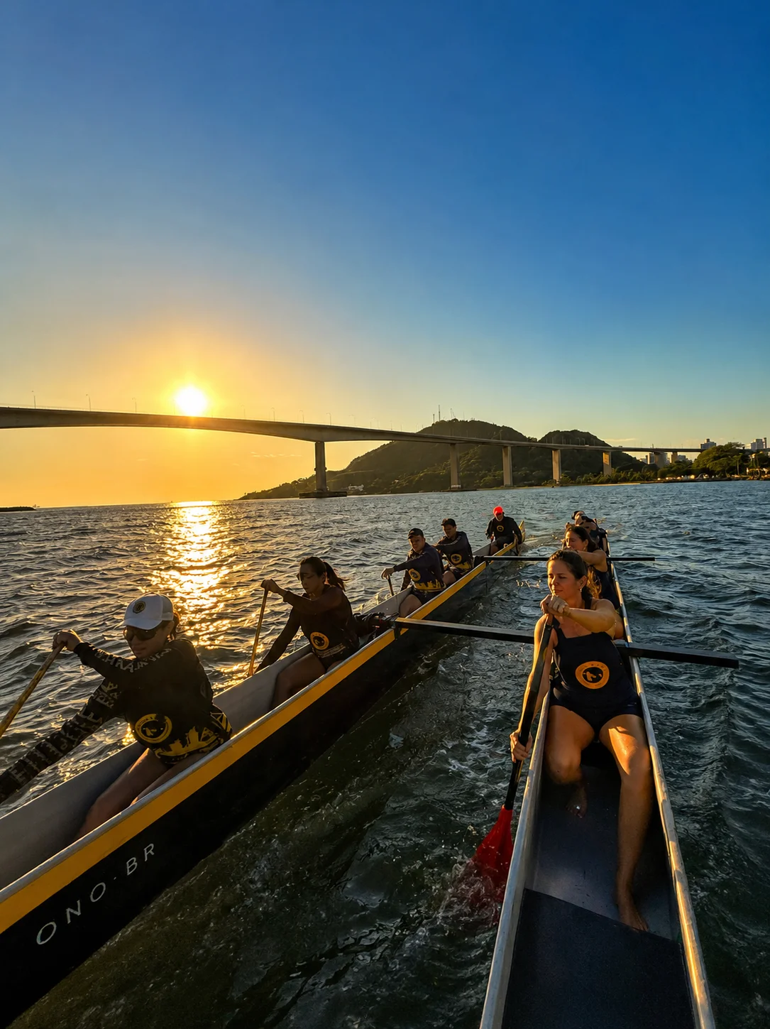 Remada em canoa havaiana ao pôr do sol, com a Terceira Ponte ao fundo